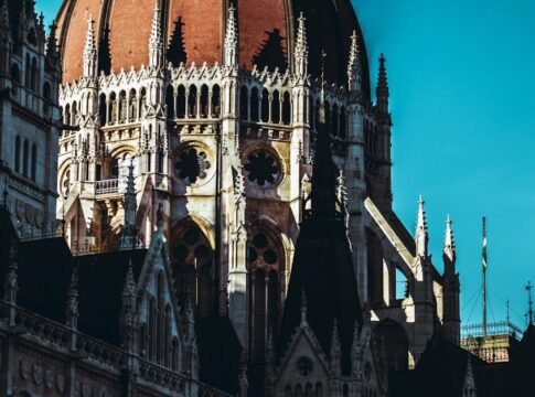 The iconic dome of the Hungarian Parliament Building in Budapest, bathed in sunlight.