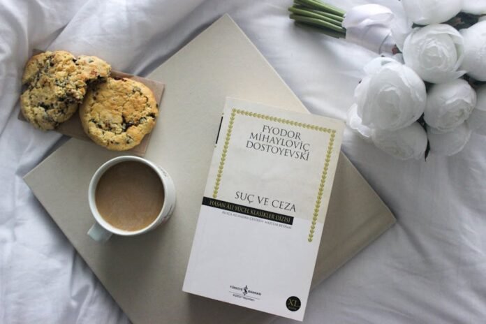 Top view of a book, coffee, and cookies on a bed with white roses. Top view of a book, coffee, and cookies on a bed with white roses.