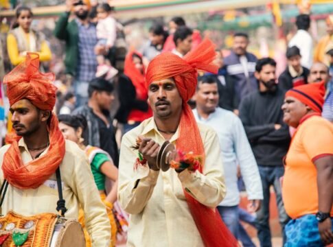 Vibrant street festival in India featuring traditional musicians in colorful attire.