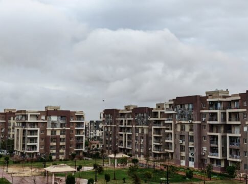 View of a modern apartment complex under a cloudy sky, showcasing urban architecture.
