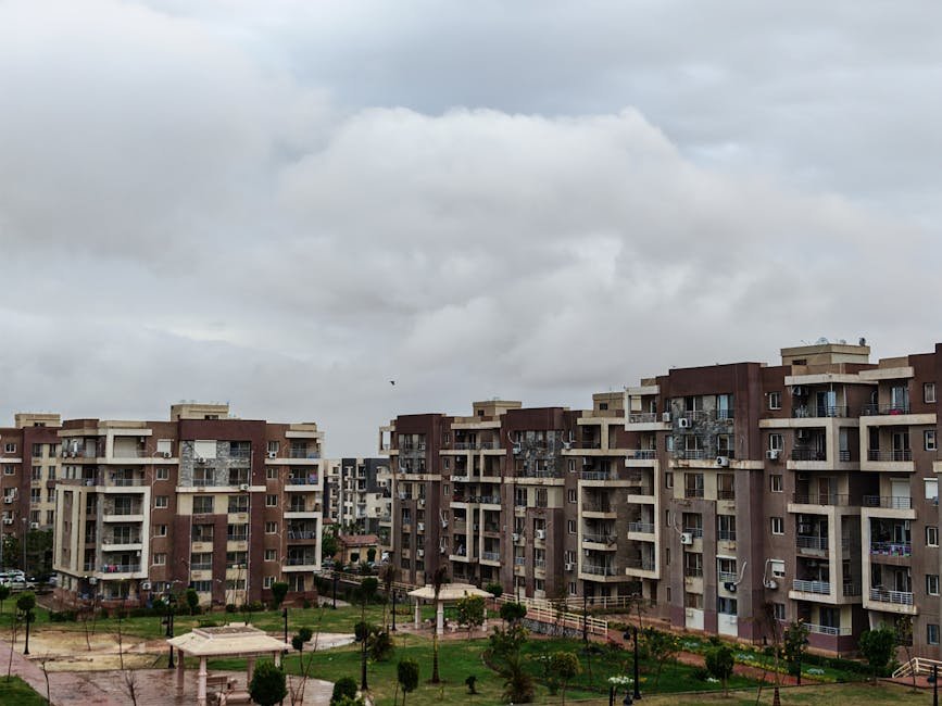 View of a modern apartment complex under a cloudy sky, showcasing urban architecture.