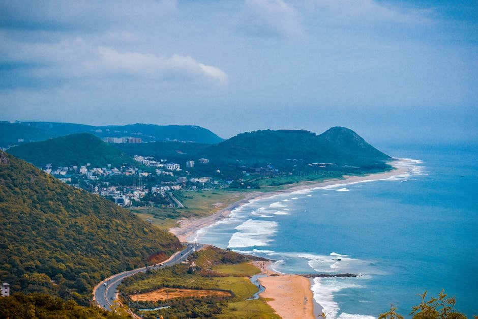Andhra Pradesh: Visakhapatnam Collector Reviews Comprehensive Mobility Plan with Stakeholders A breathtaking aerial view of the coastline in Visakhapatnam, capturing lush hills and the vibrant sea.
