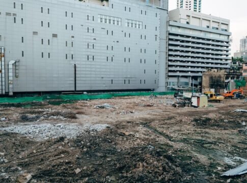 A construction site with surrounding modern buildings in an urban setting.