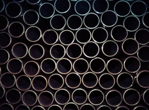 A detailed macro shot of stacked metal tubes forming a circular pattern, highlighting industrial design. A detailed macro shot of stacked metal tubes forming a circular pattern, highlighting industrial design.