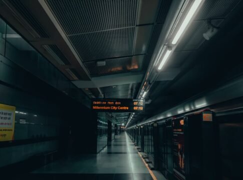 A dimly lit urban subway platform in New Delhi with signs in multiple languages. A dimly lit urban subway platform in New Delhi with signs in multiple languages.