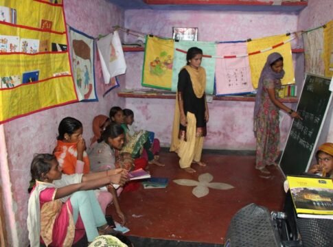 A group of Indian girls engaged in a classroom learning environment indoors.