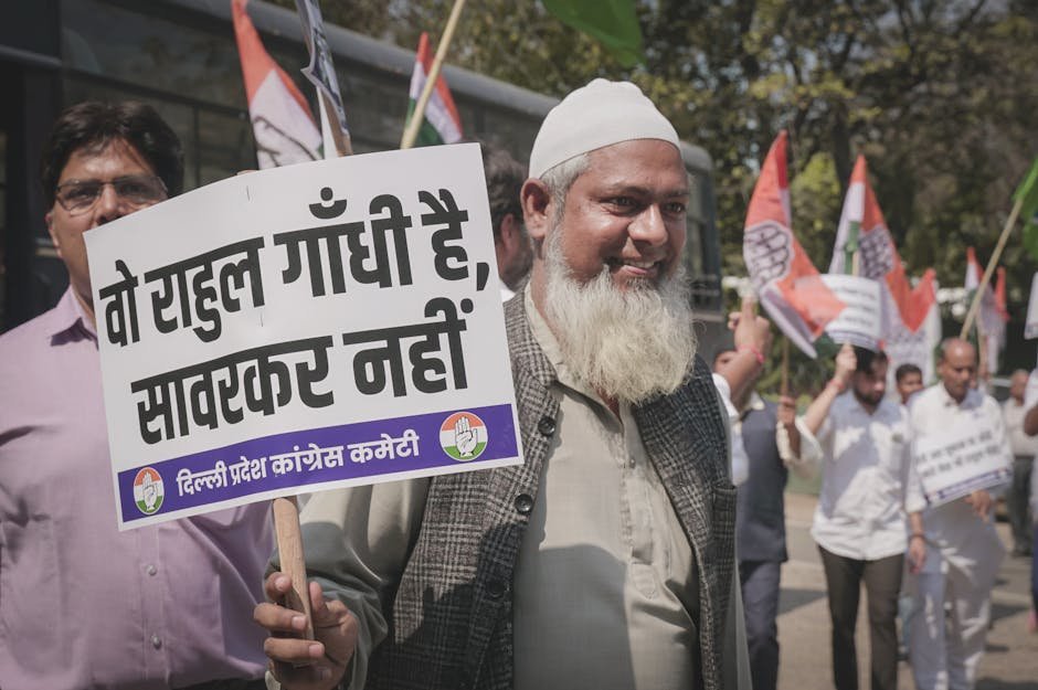 Delhi Congress Protests Price Hikes in Fuel and Milk Across Capital A man participates in a street protest holding a sign with political messaging.