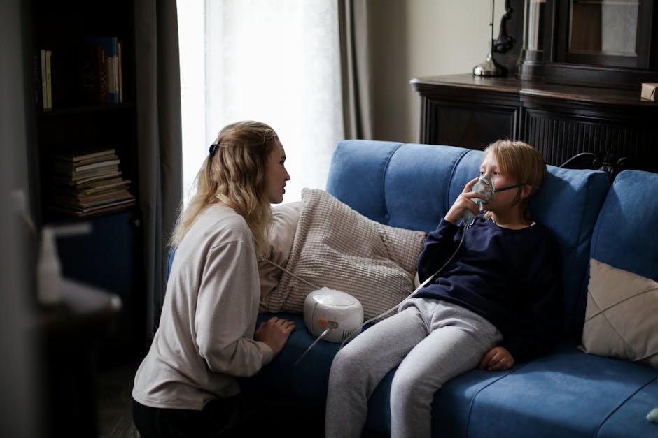 A mother assists her sick child using a nebulizer at home, providing comfort and care.