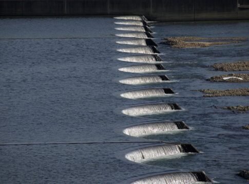 A series of cascading waterfalls over dam structures, showcasing flowing water and stone formations. A series of cascading waterfalls over dam structures, showcasing flowing water and stone formations.