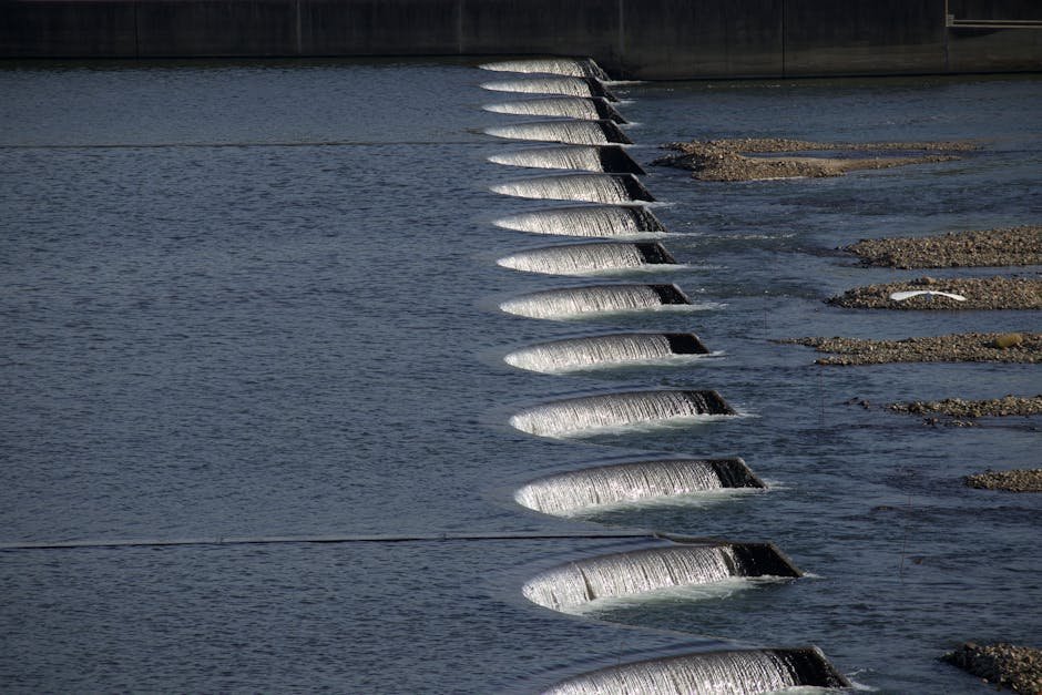 Tamil Nadu CM Orders Continued Legal Action on Mekedatu Dam Dispute A series of cascading waterfalls over dam structures, showcasing flowing water and stone formations.