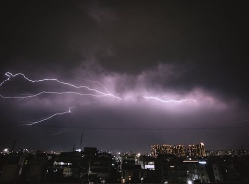 A striking lightning storm illuminates the night sky over an urban cityscape, capturing the power of nature.