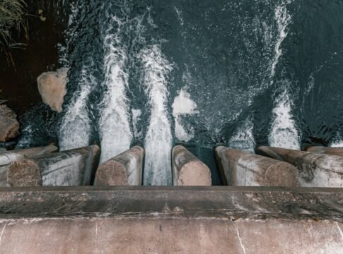 Aerial view of cascading water over a concrete dam showcasing turbulent flow and water management.