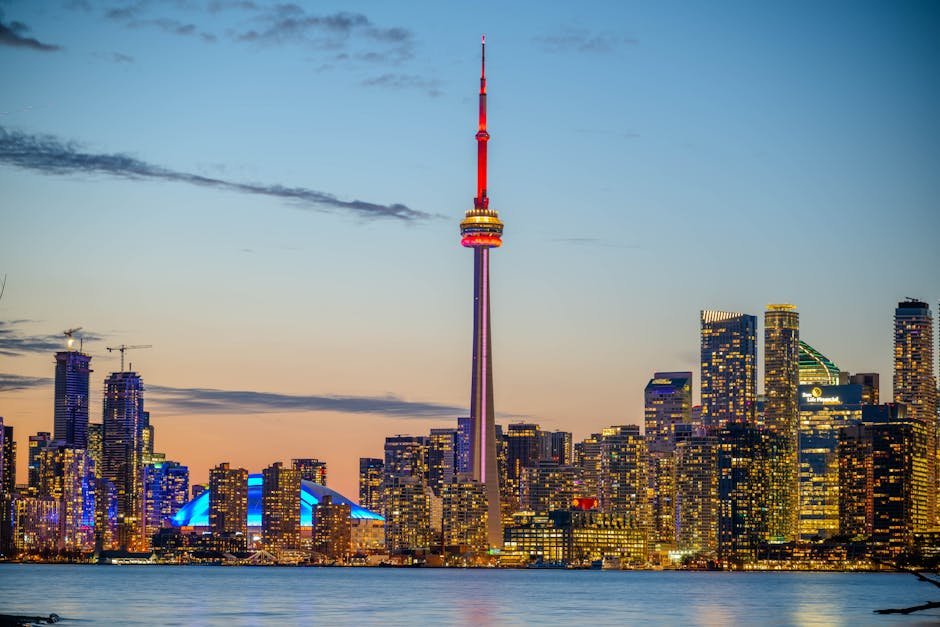 Toronto’s Underground Scene Thrives in Basement Parties, Reflecting Caribbean Diaspora’s Vibrant Culture Beautiful sunset view of Toronto skyline with CN Tower and city lights reflecting on the lake.