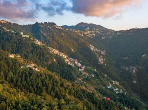 Breathtaking view of Shimla's lush green mountains with scattered houses during sunrise. Breathtaking view of Shimla's lush green mountains with scattered houses during sunrise.