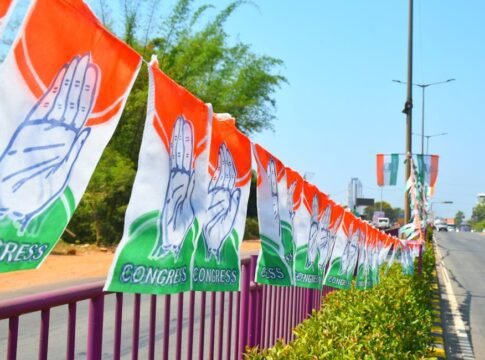Congress party flags hanging on a roadside railing in Mangaluru, India, symbolizing political promotion.
