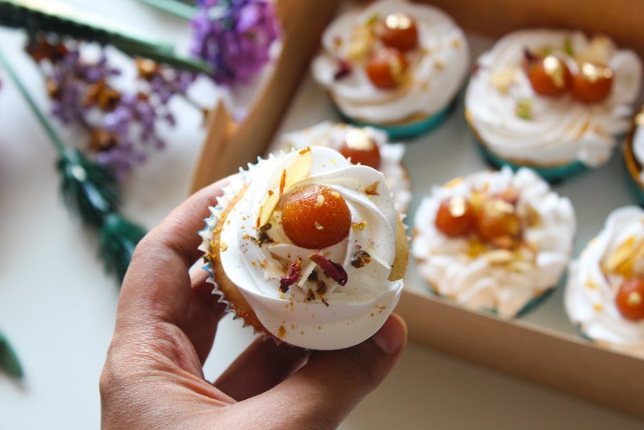 Delicious cupcake topped with Gulab Jamun and cream, perfect for dessert lovers.