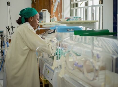 Doctor attending to newborns in an incubator in a hospital neonatal unit.