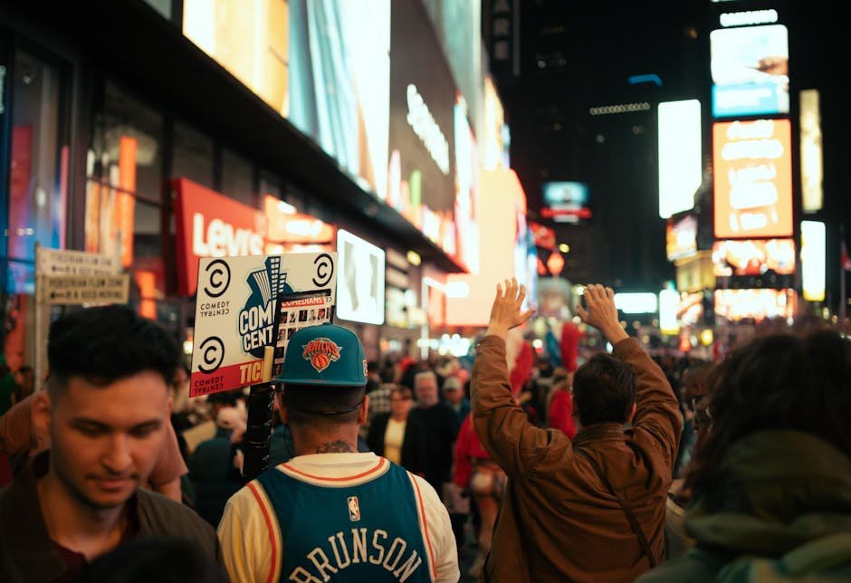 New York Knicks Return to NBA Finals for First Time Since 1999 After Sweeping Cleveland Cavaliers Dynamic night scene in Times Square, NYC with vibrant crowd and iconic neon lights.
