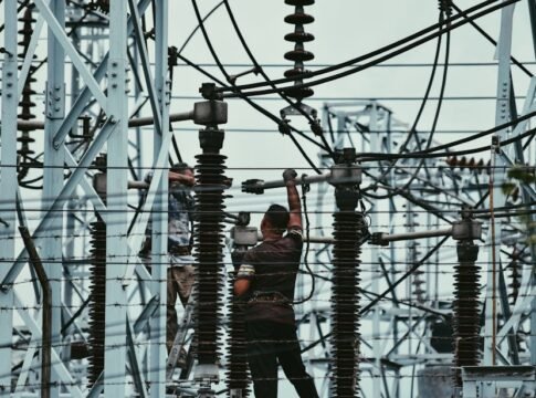Electricians working on power lines, ensuring grid maintenance and safety.