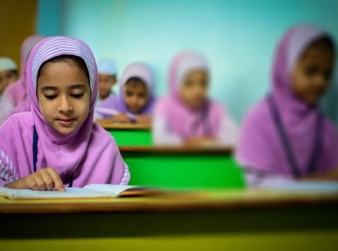 Group of young students in traditional hijabs focusing on their studies in a classroom.