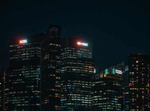 Illuminated city skyscrapers of major banks in Singapore's financial district at night. Illuminated city skyscrapers of major banks in Singapore's financial district at night.