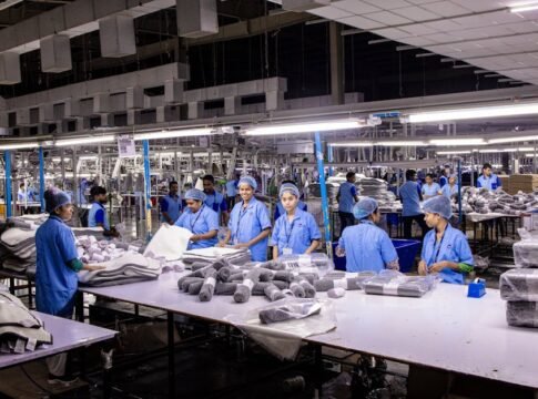Indian textile factory workers expertly packaging products on an assembly line.