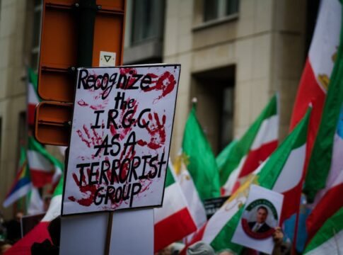 Protest in Brussels with flags and signs demanding IRGC recognition as a terrorist group.
