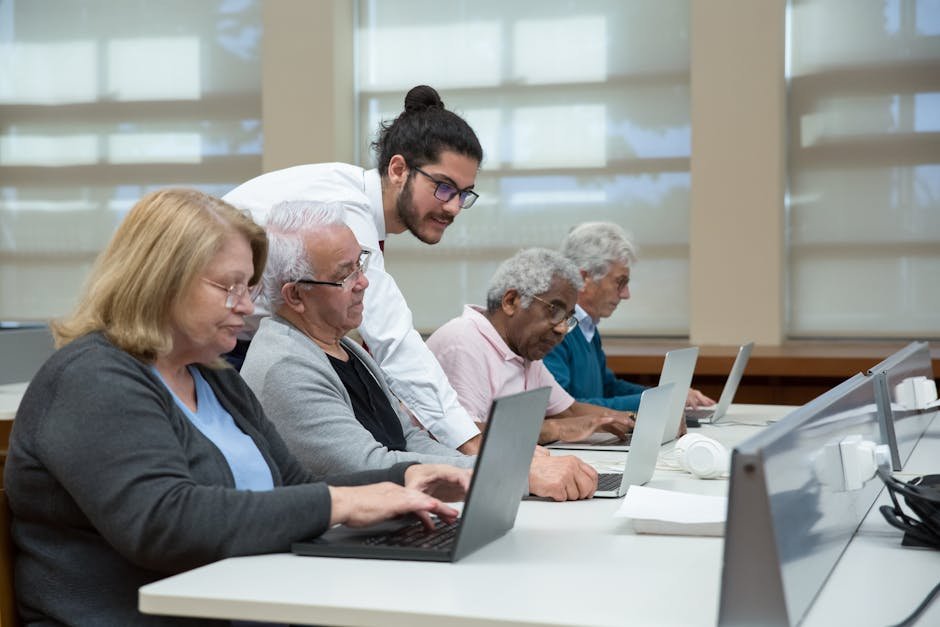 Uttar Pradesh Village Sees Elderly Residents Embrace Education for First Time Senior adults use laptops in a classroom setting, guided by a young instructor.