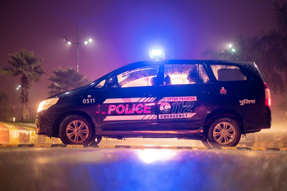 Bangladeshi National Sentenced to Three Years in Uttar Pradesh for Forging Indian Passport Side view of Uttar Pradesh police car parked at night, illuminated by neon lights and street lamps.
