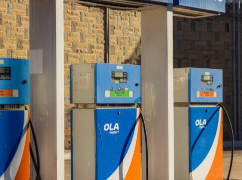 Three blue OLA Energy gas pumps at an outdoor station on a sunny day. Three blue OLA Energy gas pumps at an outdoor station on a sunny day.