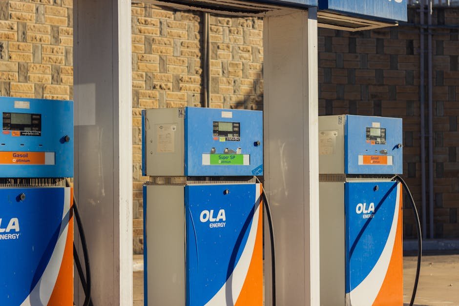 Bengaluru Witnesses Third Fuel Price Hike in Eight Days; Transport Sector Warns of Ripple Effect Three blue OLA Energy gas pumps at an outdoor station on a sunny day.