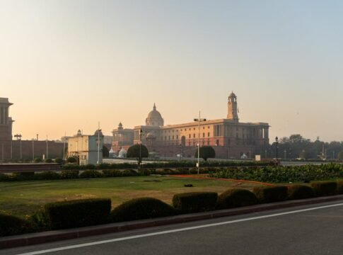 View of Rashtrapati Bhavan in New Delhi with manicured gardens and sunrise sky. View of Rashtrapati Bhavan in New Delhi with manicured gardens and sunrise sky.