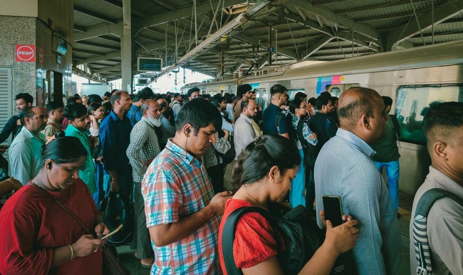 Mumbai Metro Line 6 Deadline Looms as Land Disputes Stall Key Sections A bustling scene of commuters waiting on a Mumbai train station platform. Captures Mumbai's daily life.