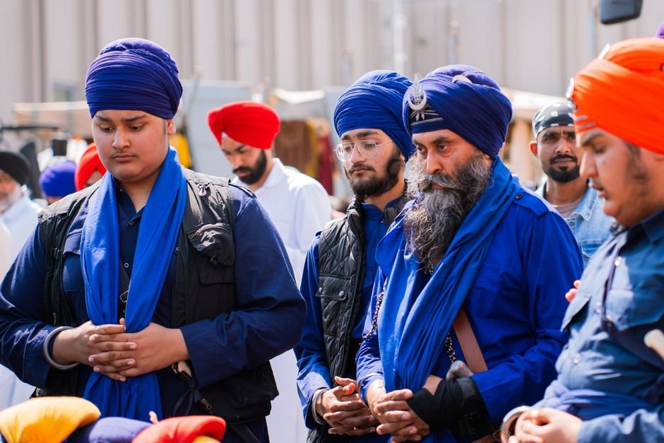 Himachal Vehicles Face Symbolic ‘Khalsa Tax’ in Punjab as Entry Levy Row Intensifies A group of Sikh men wearing traditional blue turbans participate in a peaceful assembly outdoors.