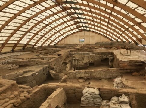 A large indoor archaeological dig showcasing ancient ruins under a protective dome structure.
