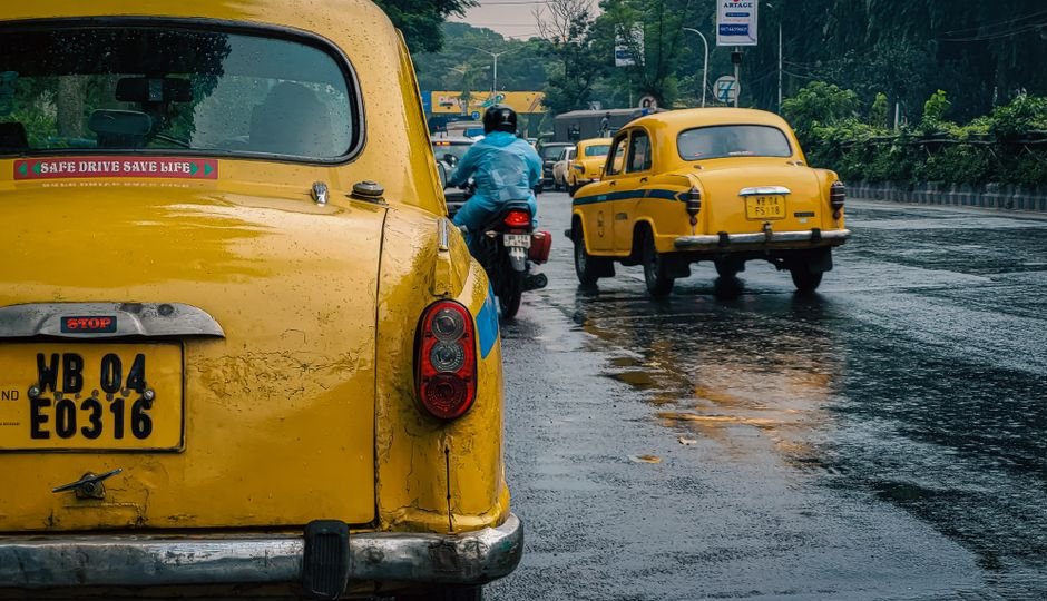 Young Activist’s 7,000-km Journey Across India Highlights Climate and Animal Welfare Concerns A rainy day scene featuring yellow taxis on a bustling street in Kolkata, India.