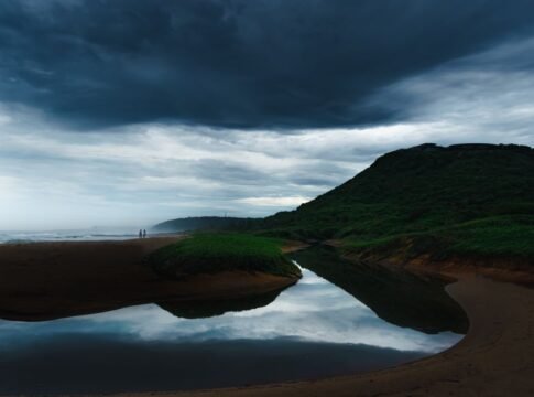A scenic view of a stormy sky over a serene coastline in Visakhapatnam, India.