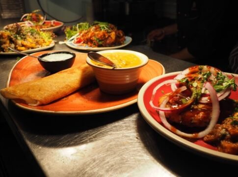A tantalizing array of Indian dishes including dosa, curry, and chutney served on vibrant plates. A tantalizing array of Indian dishes including dosa, curry, and chutney served on vibrant plates.