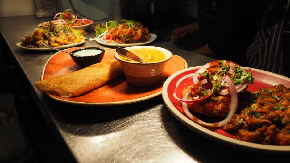 Mumbai’s Powai Welcomes Gourami: A New Culinary Destination for Authentic Mangalorean Flavors A tantalizing array of Indian dishes including dosa, curry, and chutney served on vibrant plates.
