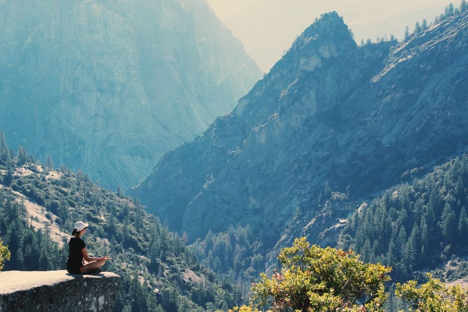 Jammu and Kashmir: Sanasar Hosts Yoga Prelude Ahead of International Yoga Day A woman practices meditation on a cliff edge, surrounded by majestic mountains and serene nature.