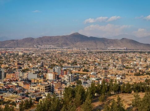 Aerial cityscape of Kabul, Afghanistan with mountains in the background.