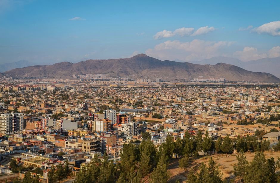 Aerial cityscape of Kabul, Afghanistan with mountains in the background.