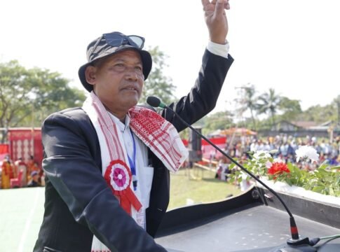 An Asian man giving a speech at an outdoor rally, gesturing with his hand. An Asian man giving a speech at an outdoor rally, gesturing with his hand.