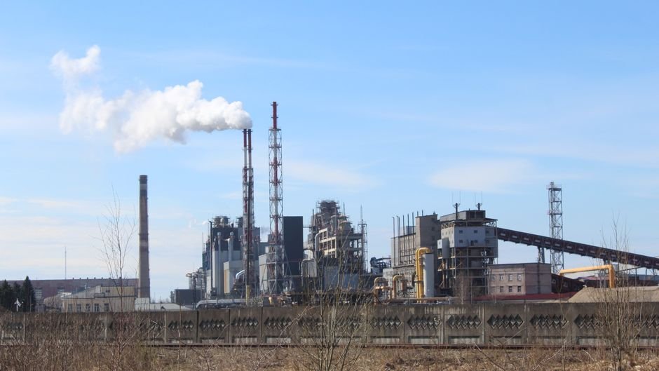 NUPPL’s Ghatampur Plant Unit-3 Commences Commercial Operations in Uttar Pradesh An industrial factory with smoke emissions against a clear blue sky.