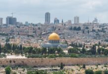 Israel, Hezbollah Agree to Ceasefire Amid Border Clashes; Iran Talks Affected Captivating aerial view of the Dome of the Rock with Jerusalem's skyline in the background.