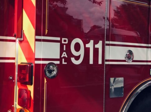 Close-up shot of a firetruck's door featuring the 911 emergency number. Close-up shot of a firetruck's door featuring the 911 emergency number.