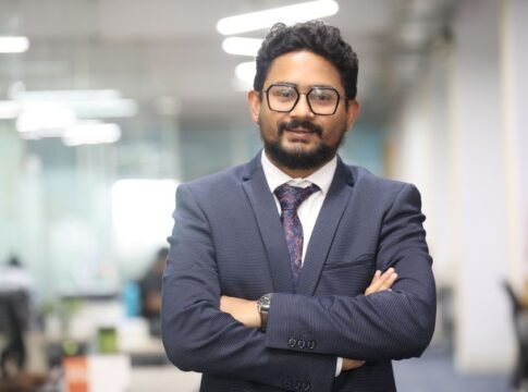 Confident man in a suit standing in a modern office, showcasing professionalism. Confident man in a suit standing in a modern office, showcasing professionalism.