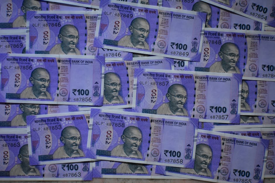 RBI Denies Gold Sale Rumors, Physical Reserves Stable at 880.52 Tonnes Detailed view of 100 Indian rupee notes featuring Mahatma Gandhi, symbolizing prosperity and economy.