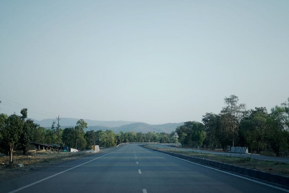 Jammu and Kashmir: Connectivity Boosted by Katra-Delhi Expressway and NH44 Upgrades, Says NHAI Empty highway through lush countryside of Ambikapur, CG, India under a clear sky.