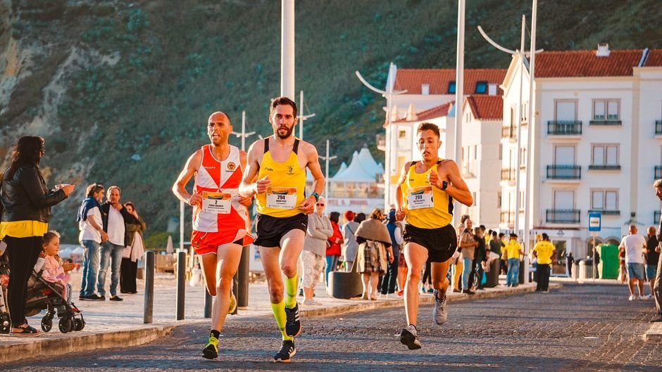 Exciting outdoor road race featuring male runners competing on a sunny day.